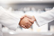 Closeup, handshake and doctors with collaboration, research and partnership for healthcare. Zoom, hand and scientists with agreements, teamwork for wellness or update for data analytics in laboratory