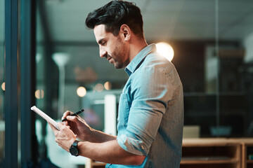 Sticker - One device, so many supportive functions. Shot of a young businessman using a digital tablet in a modern office.