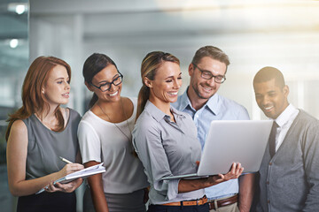 Canvas Print - Together everyone achieves more. Shot of a business team working on a laptop together.