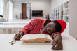 © DimaBerlin - Exhausted African guy student fall asleep while studying in library, lying on desk with textbooks in classroom, taking nap during study, selective focus. Sleep, learning, and memory. Study burnout