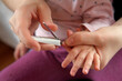 © Marina Demidiuk - Mother use Nail Trimmer with baby hand. Mom cutting tiny fingernails. Baby care concept. How to successfully clip your baby's nails. Closeup. Newborn hygiene. Clipping Child's Nails. Front view.