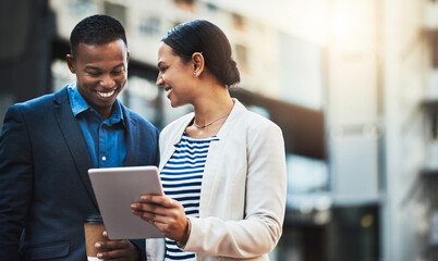 Poster - Sharing connections out in the open air. Shot of two businesspeople using a digital tablet in the city.