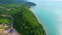 The Drone Captures The Idyllic Nature Scene Of A Tropical Coastline Dotted With Verdant Forests, A Charming Fishing Village, Majestic Mountains, Sandy Beaches, And Shimmering Turquoise Waters. 
