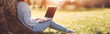 © candy1812 - Woman with laptop sitting on the grass in the natural park.