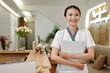 © DragonImages - Portrait of smiling spa salon receptionist holding folder