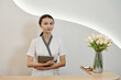 © DragonImages - Young cosmetologist with digital tablet standing at reception of spa salon