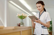 © DragonImages - Spa salon administrator checkinf schedule on tablet computer