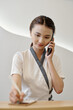 © DragonImages - Spa salon receptionist talking on phone with client