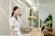 © DragonImages - Spa salon receptionist worker talking on phone with client