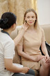 © DragonImages - Cosmetoloigst checking skin of young woman visiting spa salon