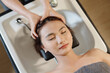 © DragonImages - Young woman getting deep cleanse of her hair and scalp