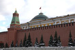 Senate Tower and Senate Palace with State flag of Russian Federation on Cupola view after high red brick Kremlin wall in winter day