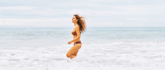 Young adorable happy woman is playing and relaxing on ocean water on at Thailand beach