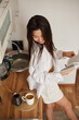 © olga pink - Young Asian woman drinking hot tasty beverage coffee and enjoying of reading book