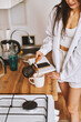 © olga pink - Young happy brunette woman making hot tasty beverage coffee, sweet breakfast, reading book