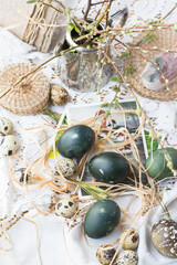 Wall Mural - Composition with Easter eggs colored with nettles in green color on table with white tablecloth in laces and decorated with branches in buds, Easter holiday table natural decoration