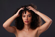 © Rethea B/peopleimages.com - Portrait, natural and hair by black woman in studio for beauty, treatment and body care on black background. Face, girl and curly afro model relax with luxury, soft and glowing skin while isolated