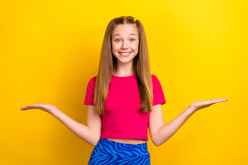 Wall Mural - Portrait of optimistic lovely nice girl with long hairdo dressed pink top palms comparing products isolated on yellow color background