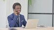 © stockbakers - African Businessman Talking on Phone while using Laptop