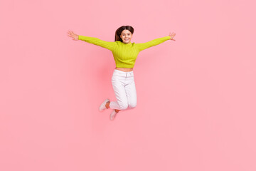 full body photo of lovely teen lady jump spread arms flight bird playful dressed stylish green cloth