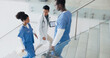 © D Lahoud/peopleimages.com - Talking, busy and doctors walking in hospital or stairs for clinic services, results or healthcare planning of documents. Research, report and nurse or professional medical people advice or strategy