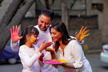 Wall Mural - young indian family celebrating holi festival