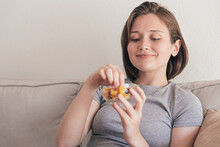 Charming woman eating tasty snack on sofa