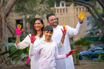 Wall Mural - young indian family celebrating holi festival