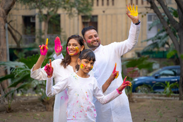 Wall Mural - young indian family celebrating holi festival