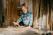 © Maskot - Senior carpenter examining picture frame at workshop