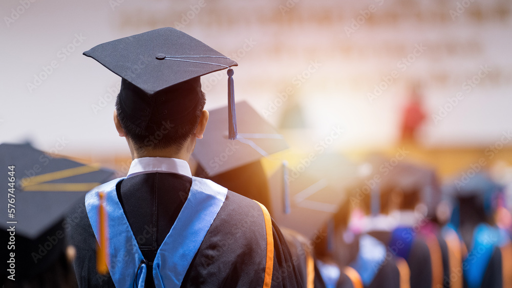 Rear view of university graduates wearing graduation gown and cap in the commencement day Stock Photo | Adobe Stock Rear view of university graduates wearing graduation gown and cap in the commencement day Stock Photo | Adobe Stock