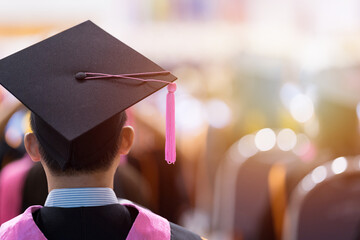 Rear view of university graduates wearing graduation gown and cap in the commencement day