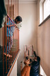 © Maskot - Father and mother talking to son while hanging painting on wall at home