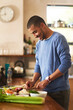 © Lyndon S/peopleimages.com - Making a healthy meal from scratch. Shot of a happy young man preparing a healthy snack at home.