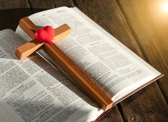 wooden cross and bible on wooden background