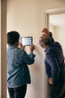 © Maskot - Senior couple looking at home automation on wall