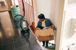 © Maskot - Senior woman carrying cardboard box while moving on stairs at home