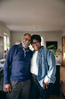 © Maskot - Portrait of smiling senior couple standing with each other at home