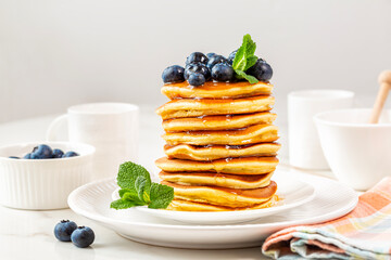 Sticker - Morning, homemade  breakfast, stack of pancakes with blueberries and honey or maple syrup. White table background.