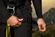 © MM - The man tightens the strap on his leg. Insurance system. For work at height. industrial mountaineering, tourism, height. In the mountains