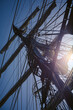 Masts, ropes, sails, ladder and hauled in sails of a historic sailing ship with a blue sky