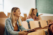 © Drazen - Young happy woman using touchpad while attending lecture at university.