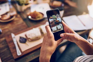 Poster - This looks too delicious to just eat and not snap. Cropped shot of a woman taking a picture on her phone of her food.