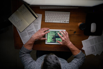 Wall Mural - Hes determined to make that deadline. High angle shot of an unidentifiable computer programmer working alone late at night.