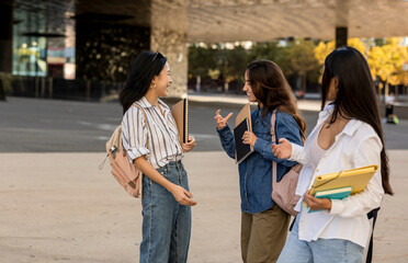 Millennial friends sitting together downtown lifestyle concept - Happy guys and girls having fun talking on Barcelona street - College students on travel vacation