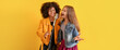 © Pixel-Shot - Teenage girls singing in microphone against yellow background