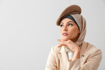 Stylish Muslim woman on light background, closeup