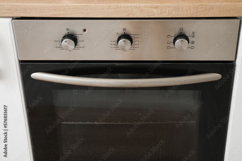 Electric oven with knobs in kitchen, closeup