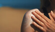 © M-Production - Woman applying sunblock cream on her shoulder.