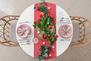 Sticker - Setting for International Women's Day celebration with burning candles, tulip flowers and eucalyptus branches on table